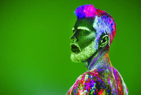 Concept. Portrait of a bearded man. The man is painted in ultraviolet powderの写真素材