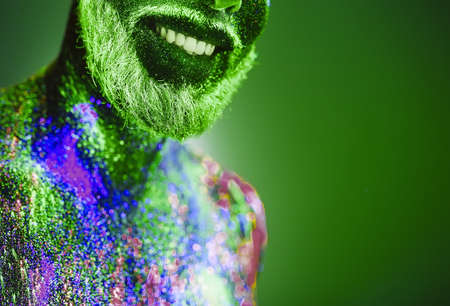 Concept. Portrait of a bearded man. The man is painted in ultraviolet powderの写真素材