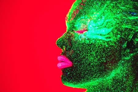 Portrait of a girl painted in fluorescent powder.の写真素材