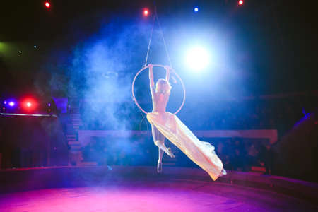 Aerial acrobat in the ring. A young girl performs the acrobatic elements in the air ringの素材 [FY310128219272]