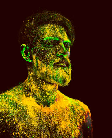 Concept. Portrait of a bearded man. The man is painted in ultraviolet powderの写真素材