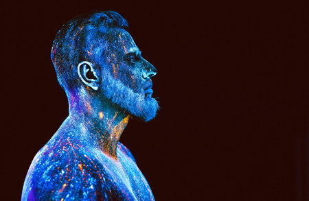 Concept. Portrait of a bearded man. The man is painted in ultraviolet powder
