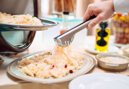 Sauerkraut. Breakfast at the hotel or restaurant. The waiter lays the sauerkraut in the dish.の写真素材