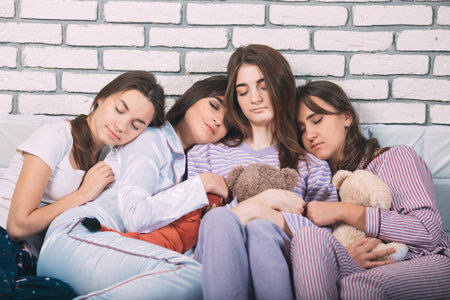 Sleeping group of young people in a bad.