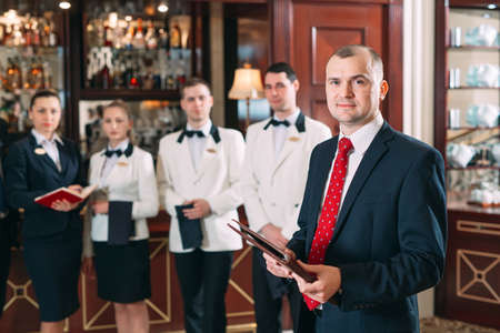 The interaction of the staff. Hotel or restaurant manager and his staff in kitchen. interacting to head chef in commercial kitchen.の写真素材