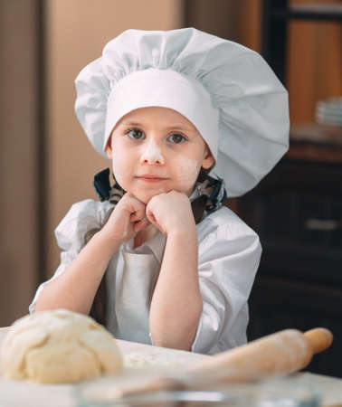 girl kid are preparing the dough in the kitchen.の写真素材