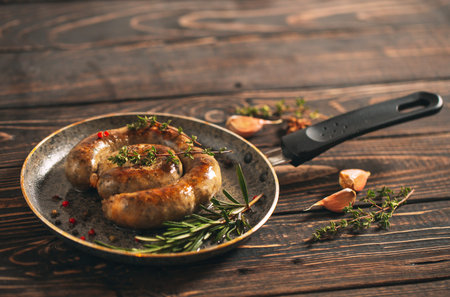 Fried sausages with garlic n the pan. On the dark Board.の写真素材
