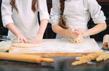funny girls kids are preparing the dough in the kitchen.の写真素材