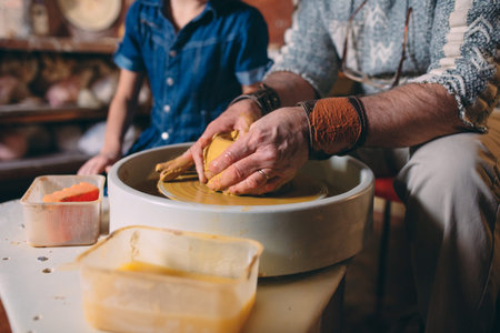 Pottery workshop. Grandpa teaches granddaughter pottery. Clay modeling
