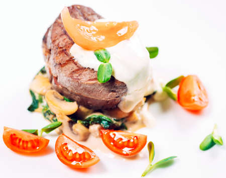 Veal medallions with spinach on the white plateの写真素材