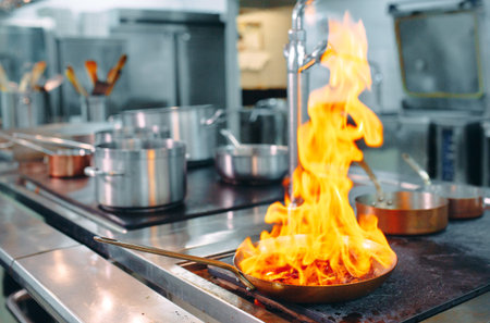 Modern kitchen. Cooks prepare meals on the stove in the kitchen of the restaurant or hotel. The fire...