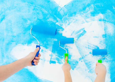 Mother, father and little daughter painting the wall in their new home.の写真素材