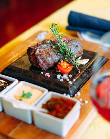 Restaurant food. Grilled pork dish with fresh vegetables. Medallions with herbs and spices.の写真素材