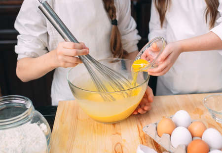 funny girls kids are preparing the dough in the kitchen.の写真素材