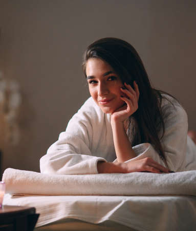 Spa, massage. A young dark-haired beautiful girl is waiting for a massage.の写真素材
