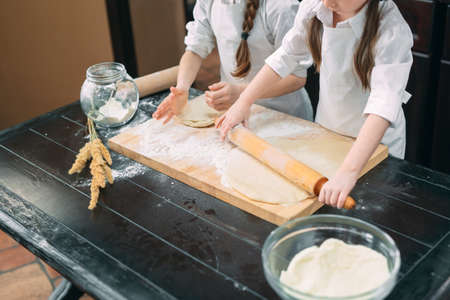 funny girls kids are preparing the dough in the kitchen.の写真素材