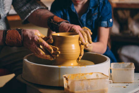 Pottery workshop. Grandpa teaches granddaughter pottery. Clay modelingの写真素材