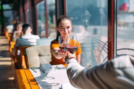 A young couple drinking wine in a restaurant near the window.の写真素材
