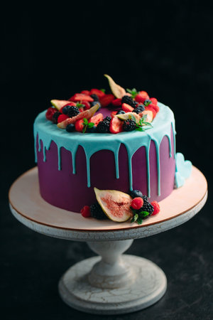 Fruit cake decorated with figs, blueberries, raspberries and mint.