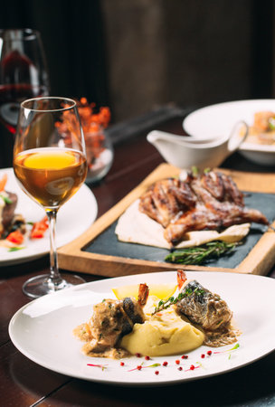 Grilled partridge, sea bass, Tartarus. Different dishes on the table in the restaurant