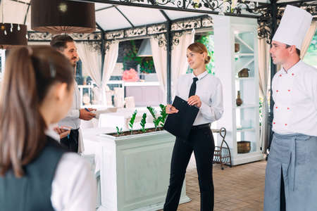 Restaurant manager and his staff in terrace. interacting to head chef in restaurant.の写真素材