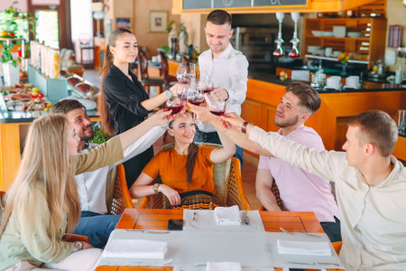 Friends drink wine on the terrace of the restaurant.