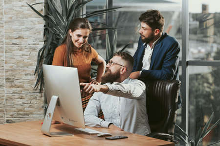 Business people in a modern office discuss work in front of the display.の写真素材