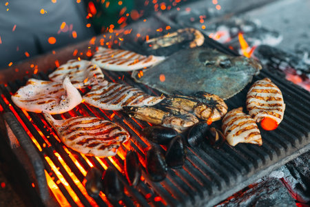 Seafood on the grill. Mussels, shrimp, squid and fish are cooked on fire.