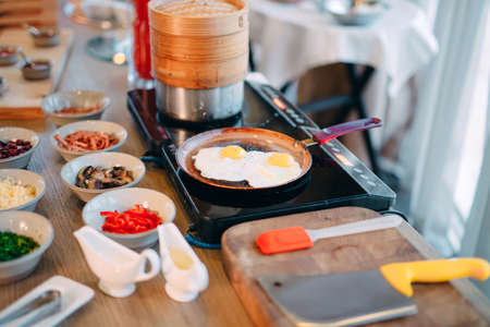 Breakfast. Scrambled eggs are cooked on an induction cooker in the restaurant.の写真素材