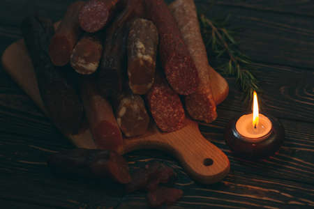 Different types of sausages and meat products on a wooden Boardの写真素材