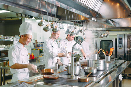 Modern kitchen. Cooks prepare meals on the stove in the kitchen of the restaurant or hotel. The fire in the kitchen.の写真素材