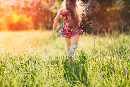 Large group of kids, friends boys and girls running in the park on sunny summer day in casual clothes .の写真素材