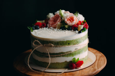 Cake is decorated with flowers on a dark background.の写真素材
