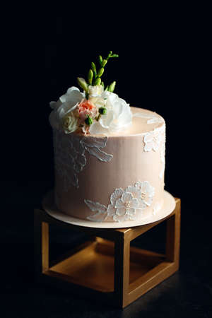 Cake is decorated with flowers on a dark background.の写真素材