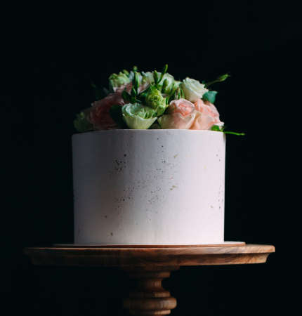 Cake is decorated with flowers on a dark background.の写真素材