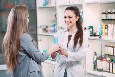 A beautiful pregnant woman consults at a pharmacy.の写真素材