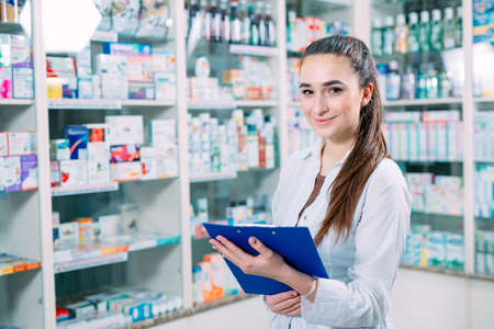 pharmacist chemist woman working in pharmacy drugstore with tablet.の写真素材