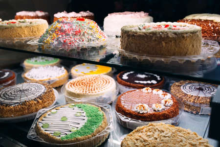 Pastry shop glass display with selection of cream or fruit cake.の写真素材