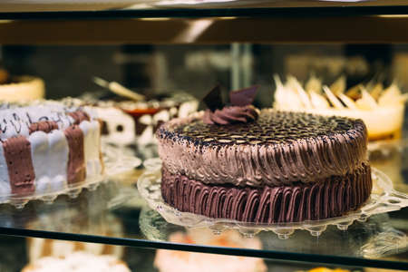 Pastry shop glass display with selection of cream or fruit cake.の写真素材