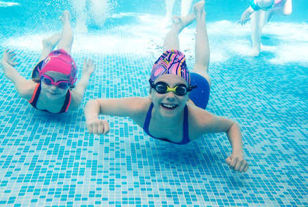 Underwater photo of young friends in swimming pool.の写真素材