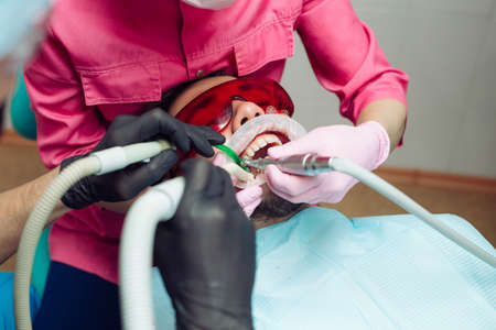 Professional teeth cleaning. Dentist cleans the teeth of a male patient.の写真素材