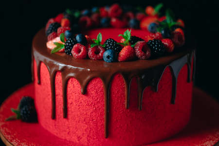 Red velvet summer fruit cake on the black background.の写真素材