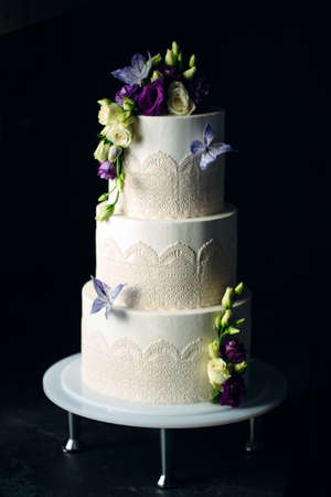 Cake is decorated with flowers on a dark background.の写真素材