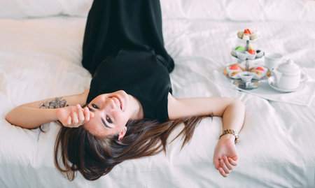The girl is lying on the bed in a hotel room or at home.