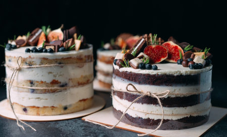 Fruit cake decorated with figs, cookies and blueberries.
