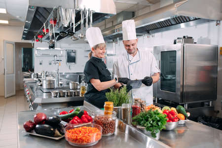 Two chefs discuss the menu in the kitchen of a restaurant or hotel.の写真素材