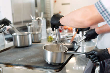 Cooks prepare meals on an electric stove in a professional kitchen in a restaurant or hotel.の写真素材