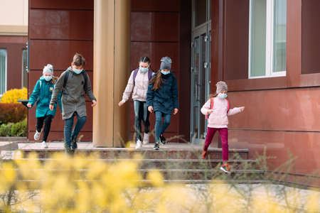 Children students in medical masks leave the school.の写真素材