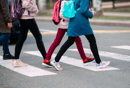 School children cross the road in medical masks. Children go to school.の写真素材