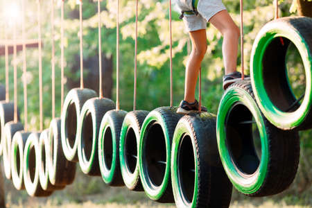 rope park. A boy passes an obstacle on tires in a rope Park.の写真素材